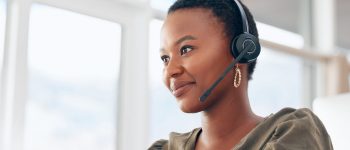 If you need us, call. Shot of a woman wearing a headset while working in a call centre.
